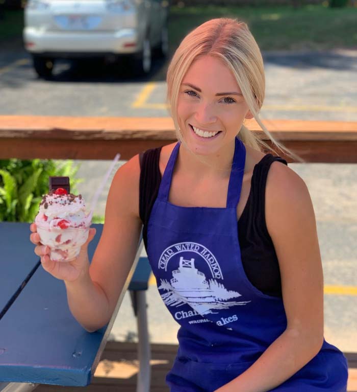 Waitress holds hand scooped sweet treats at Moo's Ice Cream Shoppe at Clear Water Harbor in Waupaca, WI